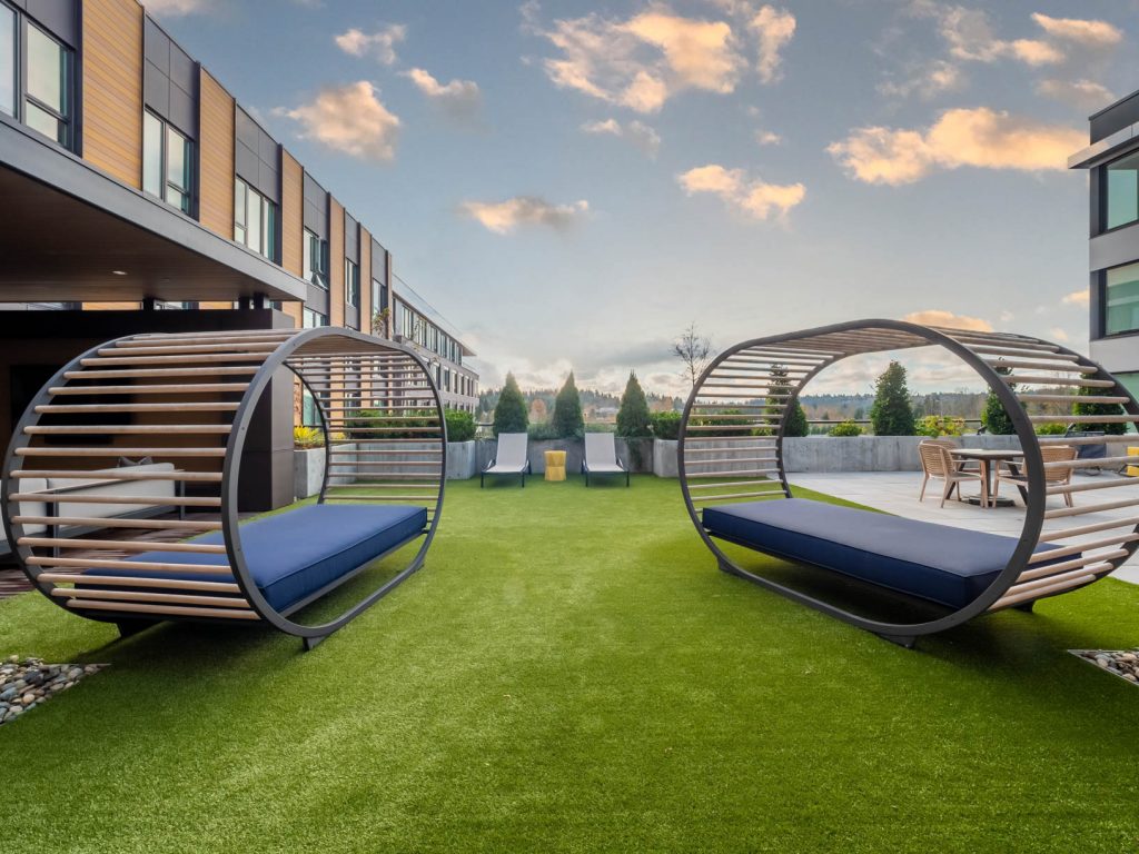 Outdoor deck area with sun tanning beds with lounge and table seating