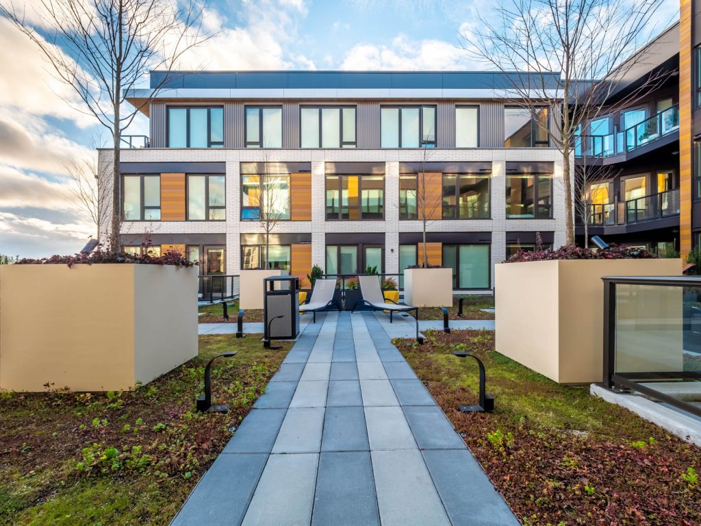 Courtyard with chaise lounge chairs, path lighting and raised tree planters