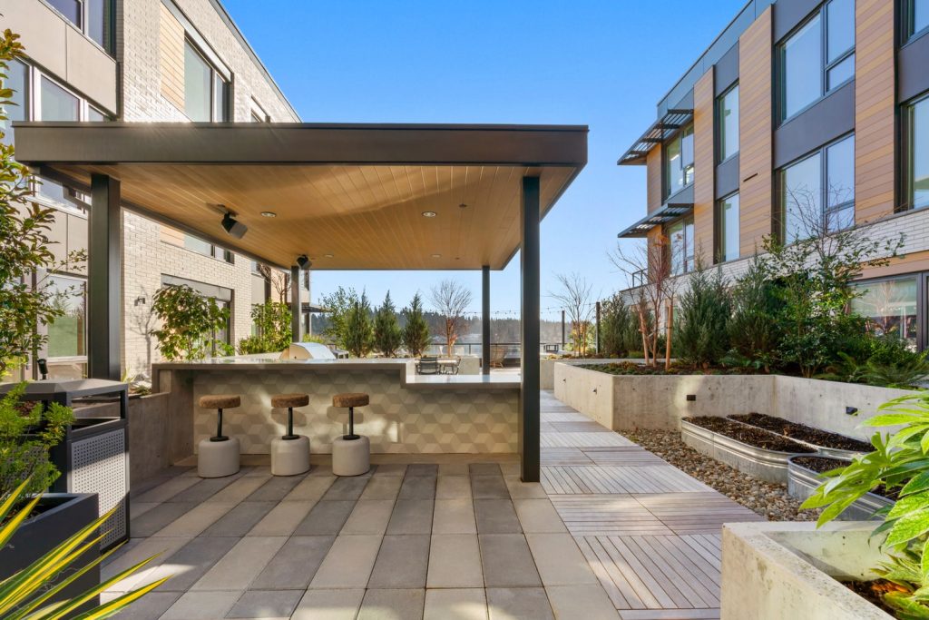 Covered outdoor grill area with peninsula bar counter and bar stool seating.